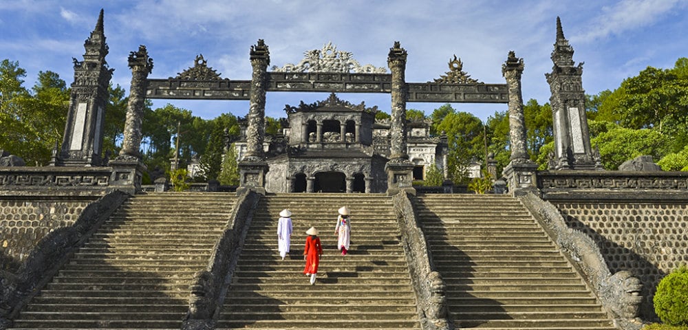 The journey begins with the Tam Quan Gate, an imposing three-arched entrance that marks the threshold to the mausoleum